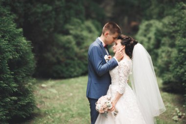 Yeni evli çift el ele tutuşurken parkta koşup zıplıyorlar..