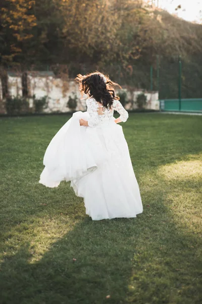 美丽的新娘穿着完美的衣服在公园里纺纱 — 图库照片