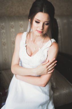 Cüppeli muhteşem gelin bir odada düğün töreni için poz veriyor ve hazırlanıyor..