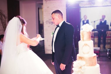 Gelin ve damat düğün pastasını kesiyor.