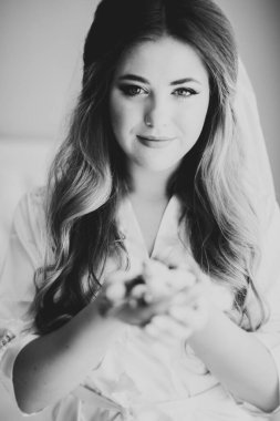 Cüppeli muhteşem gelin bir odada düğün töreni için poz veriyor ve hazırlanıyor.