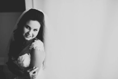 Çekici gelinin portresi, uzun saçlı, büyük buketli poz veren..