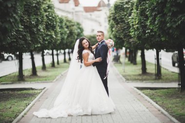 Güzel gelin ve damat düğün günlerinde kucaklaşıp öpüşürler..