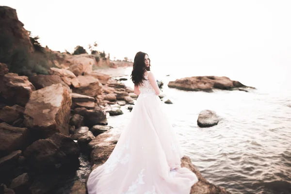 Portrait of stunning bride with long hair posing with great bouquet.