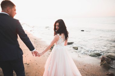 Güzel bir sahilde poz veren genç bir çiftin mutlu ve romantik sahnesi..