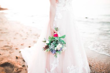 Gelin çiçekli büyük ve güzel bir düğün buketi tutuyor..