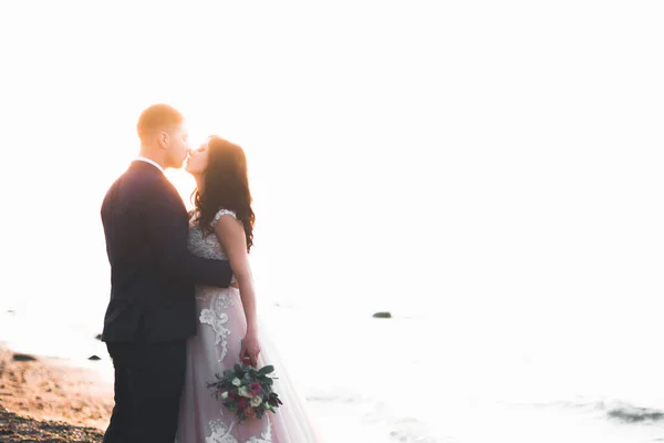 結婚式のカップル 海と青空の近くにポーズ花束と花嫁 — ストック写真