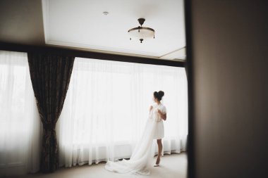 Beyaz elbiseli lüks gelin düğün törenine hazırlanırken poz veriyor..