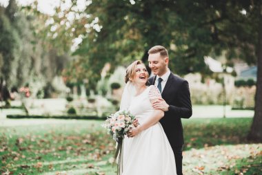 Yeni evli çift el ele tutuşurken parkta koşup zıplıyorlar..