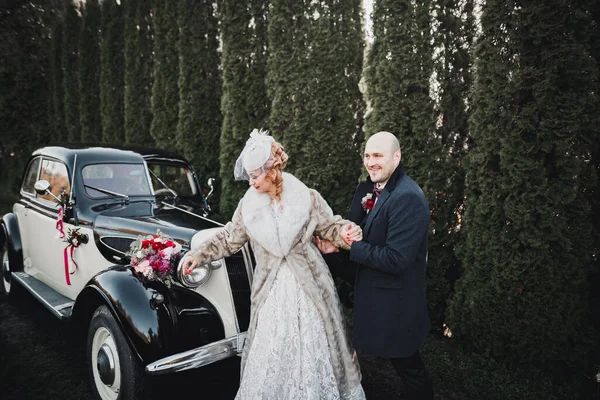 幸せな新婚者のカップル 男と妻のスタイリッシュなレトロな車の近くにキス — ストック写真