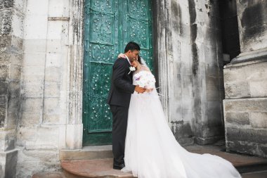 Doğadaki düğün çifti birbirine sarılıyor. Beyaz elbiseli güzel bir kız. Takım elbiseli adam.