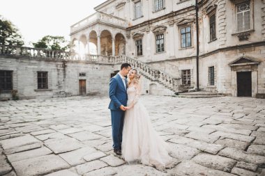 Romantik düğün anı, yeni evli çiftin gülümseyen portresi, gelin ve damadın kucaklaşması.