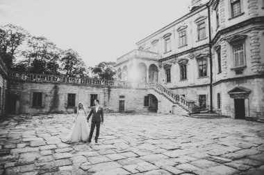 Romantik düğün anı, yeni evli çiftin gülümseyen portresi, gelin ve damadın kucaklaşması.