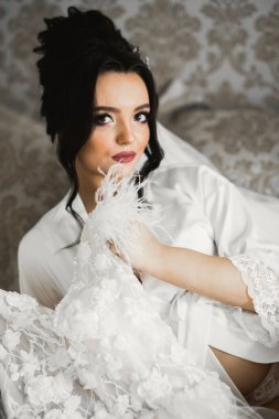 Beyaz elbiseli lüks gelin düğün törenine hazırlanırken poz veriyor..