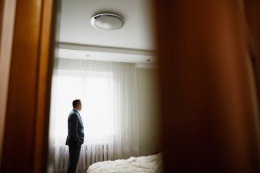 Güzel adam, damat poz veriyor ve düğüne hazırlanıyor..