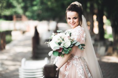 Gelin çiçekli büyük ve güzel bir düğün buketi tutuyor..