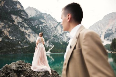 Dağlarda göl kenarında güzel modern bir çift düğün fotoğrafları çekiyor..