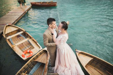 Doğadaki düğün çifti birbirine sarılıyor. Beyaz elbiseli güzel bir kız. Takım elbiseli adam.