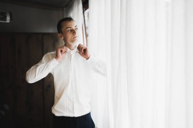 Güzel adam, damat poz veriyor ve düğüne hazırlanıyor..