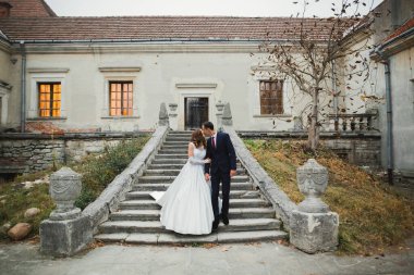 Güzel gelin ve damat düğün günlerinde kucaklaşıp öpüşürler..