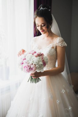 Gelin çiçekli büyük ve güzel bir düğün buketi tutuyor..