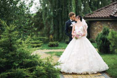 Güzel gelin ve damat evlendikleri gün kucaklaşıp öpüşüyorlar..