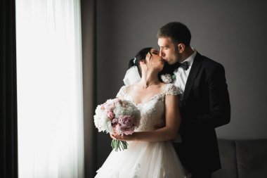 Güzel gelin ve damat düğün günlerinde kucaklaşıp öpüşürler..