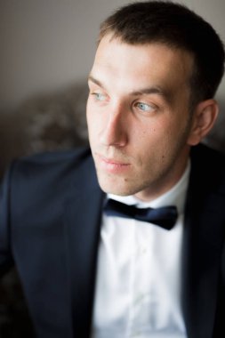 Güzel adam, damat poz veriyor ve düğüne hazırlanıyor..