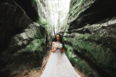 Gelin çiçekli büyük ve güzel bir düğün buketi tutuyor..