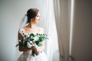 Gelin çiçekli büyük ve güzel bir düğün buketi tutuyor..