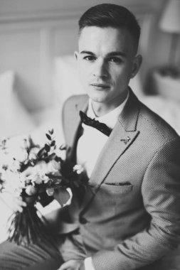 Yaka çiçeğiyle poz veren mutlu yakışıklı damat..