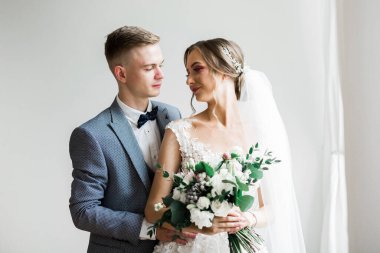 Doğadaki düğün çifti birbirine sarılıyor. Beyaz elbiseli güzel bir kız. Takım elbiseli adam.