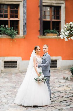 Doğadaki düğün çifti birbirine sarılıyor. Beyaz elbiseli güzel bir kız. Takım elbiseli adam.