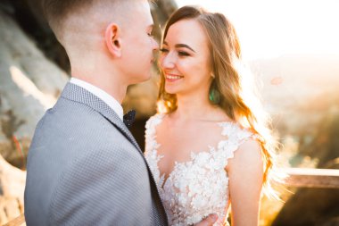 Gün batımında dağ zemin üzerine bir buket ile güzel gelin.