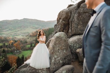 Dağların arka planında sevgi dolu bir koca ve kadın. Sevgili çift duygusal olarak vakit geçirir..