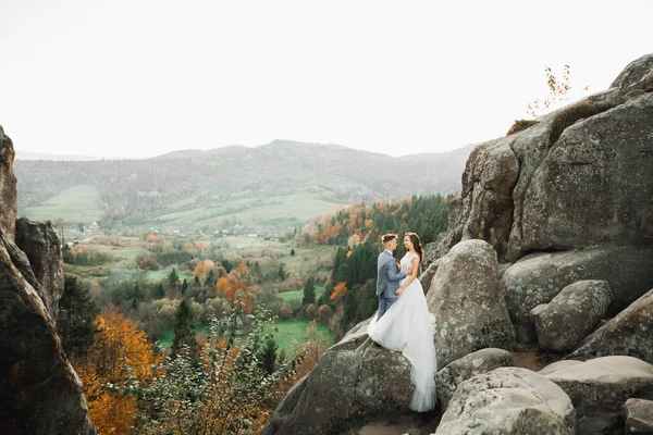 美丽华丽的新娘向新郎摆姿势 在高山边玩乐 美丽的景色 文字的空间 新婚夫妇 — 图库照片