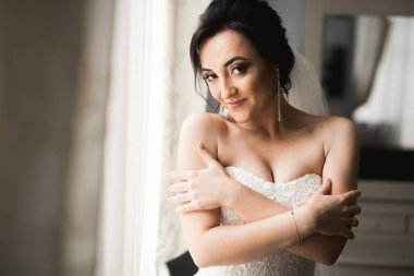 Beyaz elbiseli lüks gelin düğün törenine hazırlanırken poz veriyor..