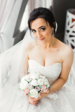 Gelin çiçekli büyük ve güzel bir düğün buketi tutuyor..