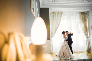 Romantik düğün anı, yeni evli çiftin gülümseyen portresi, gelin ve damadın kucaklaşması.