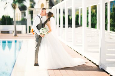 Güzel gelin ve damat düğün günlerinde kucaklaşıp öpüşürler..