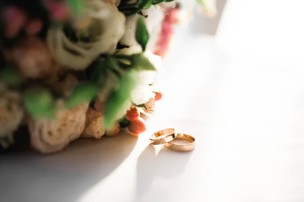 在一束鲜花的衬托下 有结婚戒指的美丽色调的照片 — 图库照片