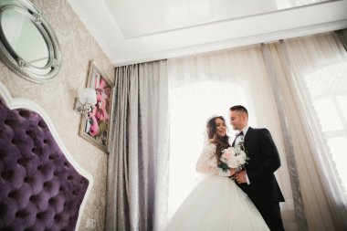 Güzel, genç bir çift ellerinde çiçeklerle poz veriyorlar..