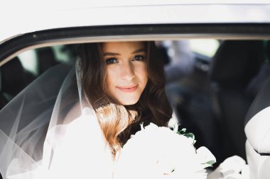 Güzel gelin düğün günü lüks bir retro arabada oturuyor..