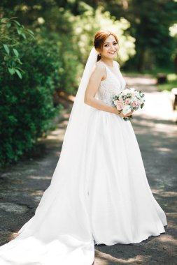 Gelin çiçekli büyük ve güzel bir düğün buketi tutuyor..