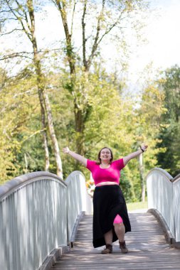happy plus size girl on a walk in the park