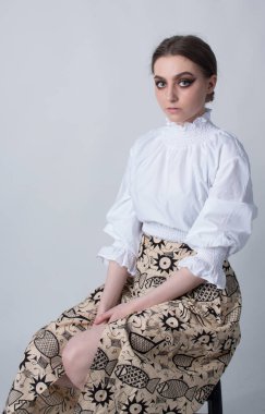 beautiful elegant female wearing a white shirt and an African inspired skirt