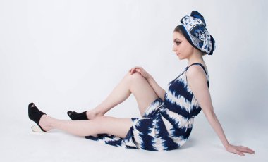 beautiful elegant female wearing a blue and while dress and head dress that is African inspired