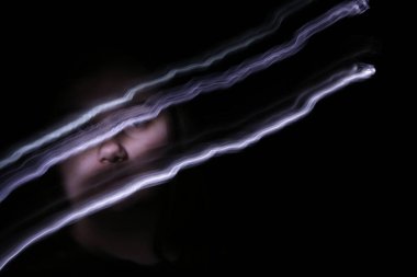 plus size woman with long exposure light trails in front of face 