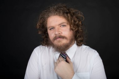 Plus size male with long curly hair and a beard wearing a business suit