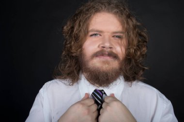 Plus size male with long curly hair and a beard wearing a business suit